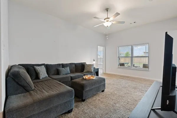 a living room with furniture and a ceiling fan