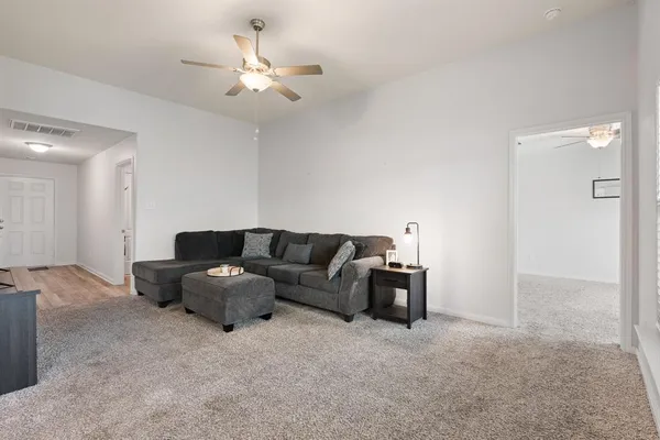 a living room with furniture and a ceiling fan