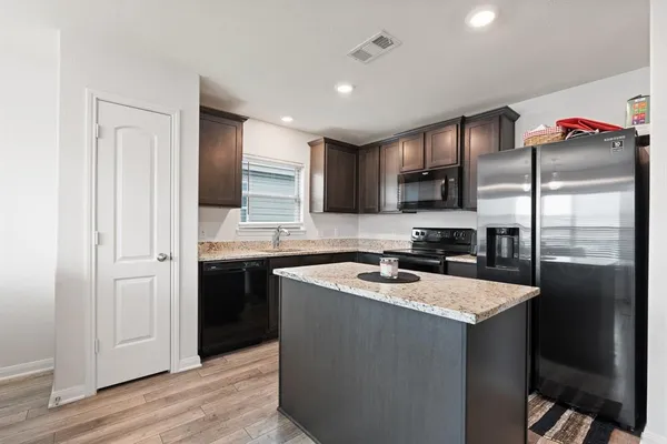 a kitchen with a refrigerator sink and cabinets