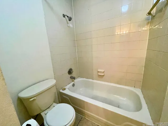 a white toilet and tub sitting next to a bathroom sink