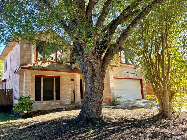 a tree in front of a white house