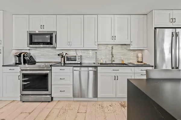 a kitchen with white cabinets and stainless steel appliances