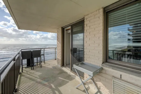 a balcony with furniture and a floor to ceiling window