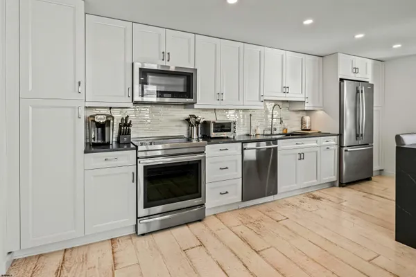 a kitchen with stainless steel appliances granite countertop a stove a sink and a refrigerator