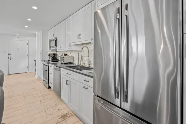 a kitchen with stainless steel appliances a refrigerator sink and cabinets