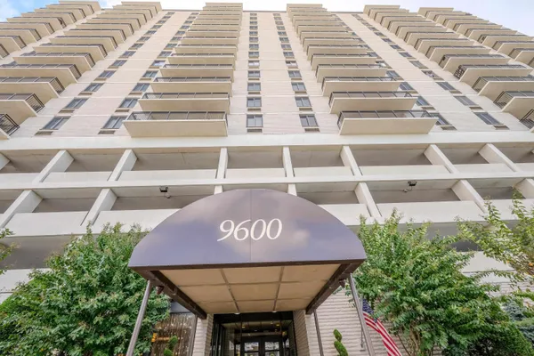 a front view of a building with a garden and plants