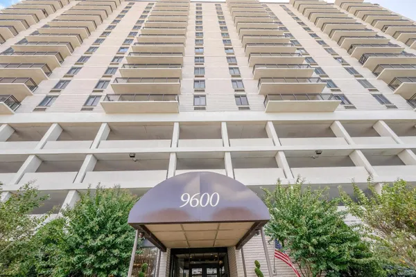 a front view of a multi story residential apartment building with a yard