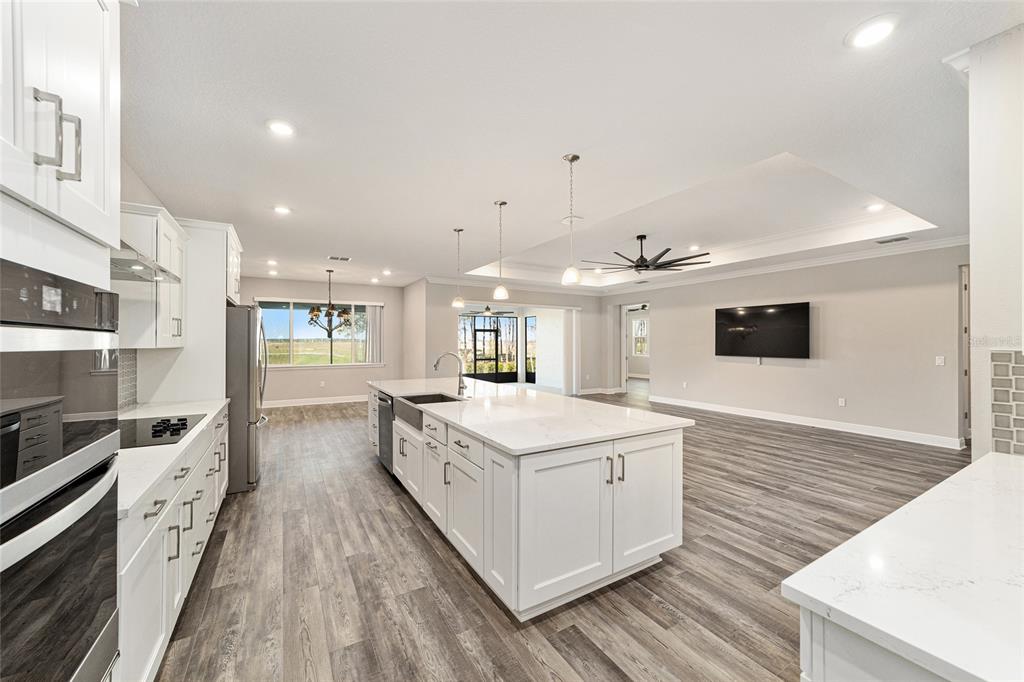 8176 Southwest 98th Terrace Road Ocala, FL 34481 - Photo 25 of 62 a open kitchen with kitchen island a stove and a wooden floors