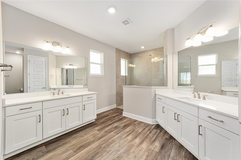8176 Southwest 98th Terrace Road Ocala, FL 34481 - Photo 32 of 62 a large bathroom with a double vanity sink and mirror with shower