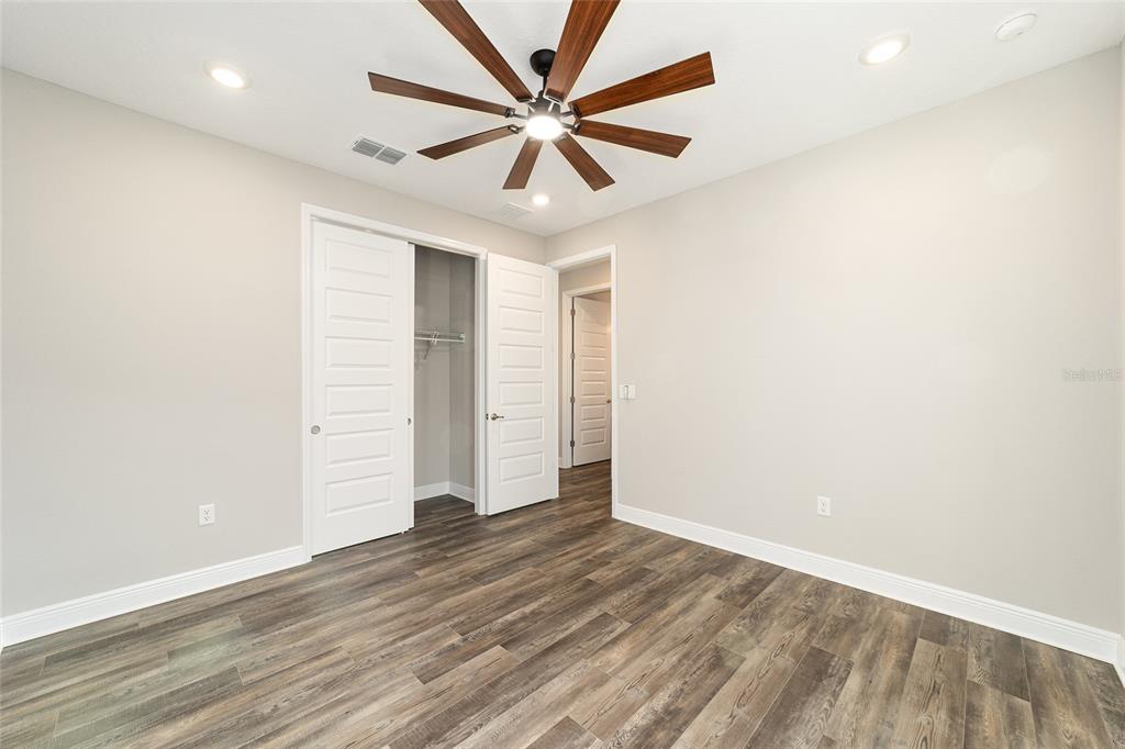 8176 Southwest 98th Terrace Road Ocala, FL 34481 - Photo 45 of 62 an empty room with wooden floor and ceiling fan