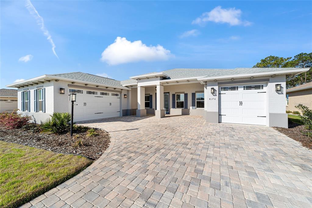 8176 Southwest 98th Terrace Road Ocala, FL 34481 - Photo 6 of 62 a view of a white house with a yard and potted plants