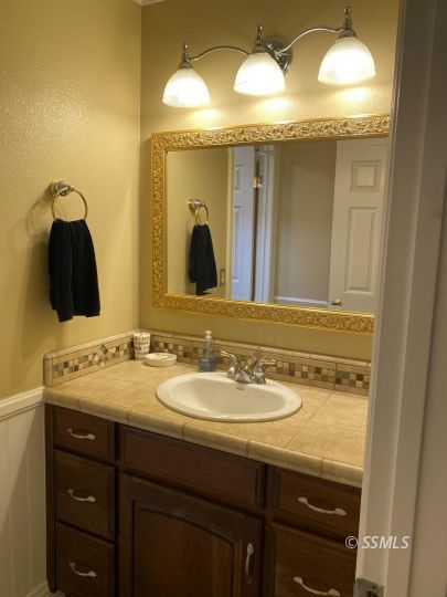 1006 North Sierra View Street Ridgecrest, CA 93555 - Photo 12 of 36 a bathroom with a double vanity sink and a mirror