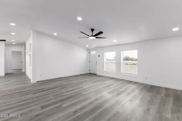 an empty room with wooden floor and windows