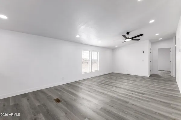 an empty room with wooden floor and windows