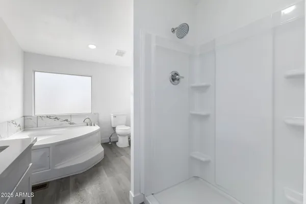 a spacious bathroom with a granite countertop sink a toilet and a mirror