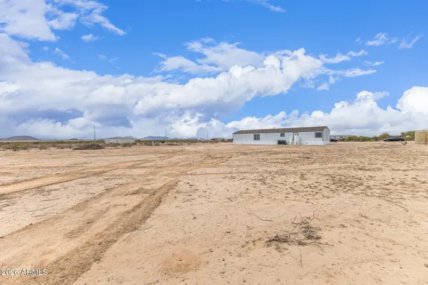 a view of a dry yard with wooden fence