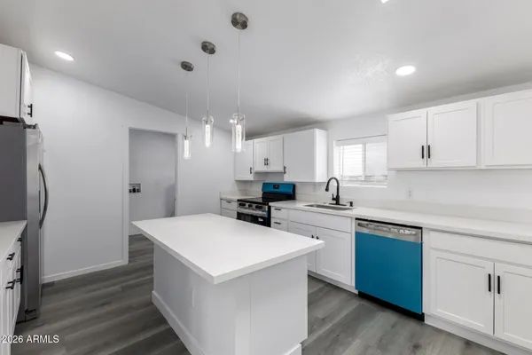 a kitchen with a sink a refrigerator and cabinets