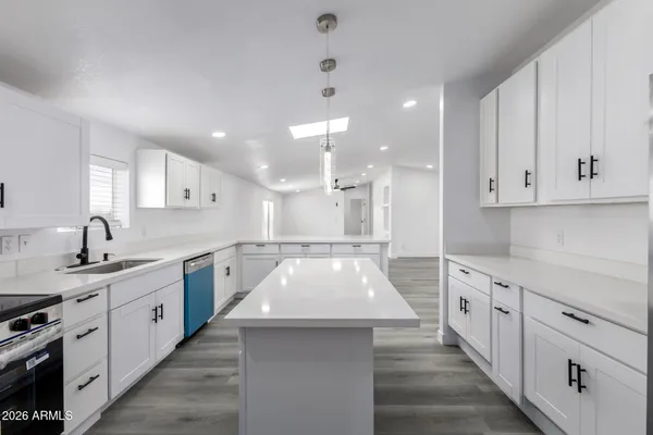 a kitchen with white cabinets appliances and sink