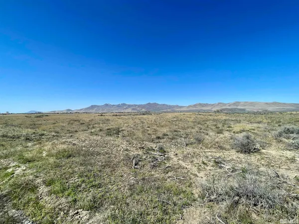 a view of a large building with mountains in the background