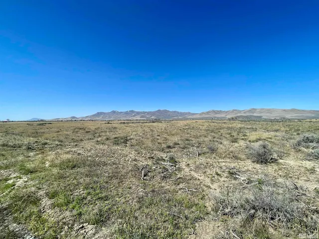 a view of a large building with mountains in the background