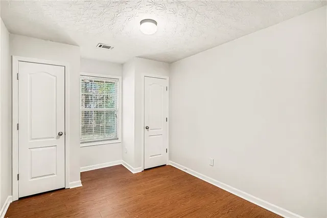 a view of an empty room with wooden floor