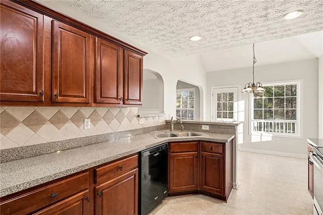 a kitchen with stainless steel appliances granite countertop wooden cabinets a sink and dishwasher