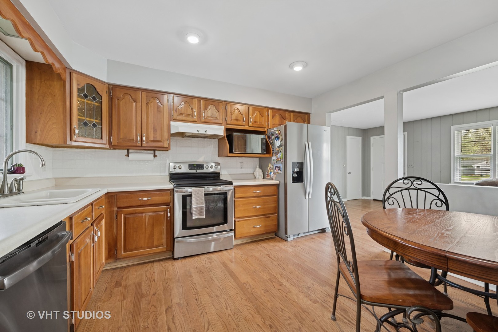 54 Burton Avenue Cary, IL 60013 - Photo 7 of 20 a kitchen with stainless steel appliances granite countertop a kitchen island hardwood floor sink stove dining table and chairs
