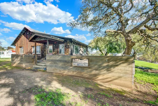a front view of a house with yard and green space