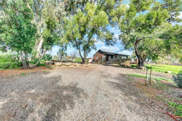 a backyard of a house with lots of green space and fountain
