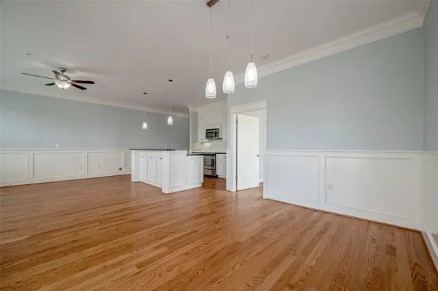 wooden floor in an empty room with a kitchen