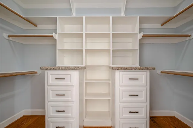 a view of walk in closet with empty racks