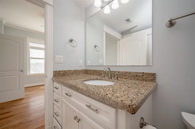 a bathroom with a granite countertop sink and a mirror