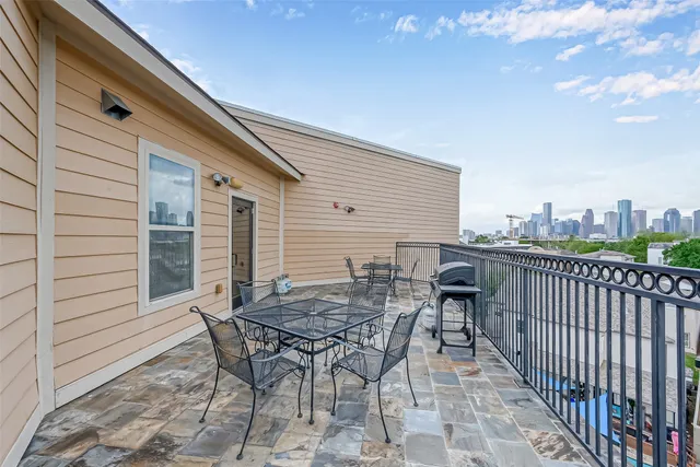 a view of a roof deck with table and chairs and wooden floor