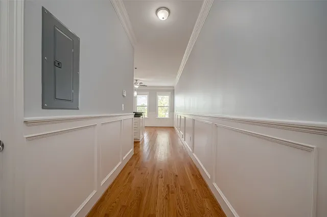 a view of a hallway with wooden floor and staircase