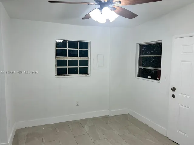 an empty room with windows and cabinet