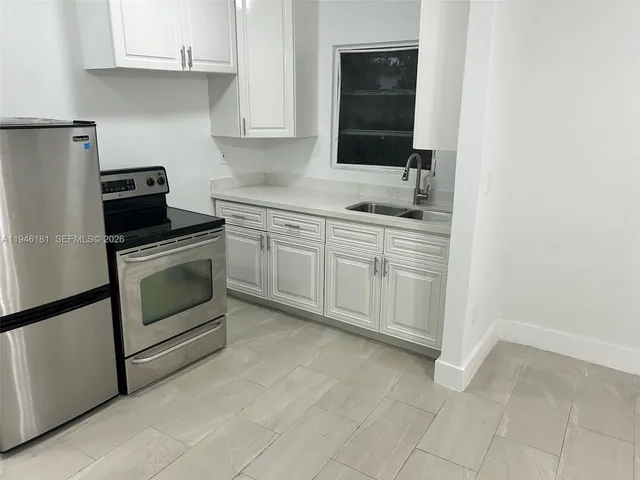 a kitchen with a stove sink and cabinets