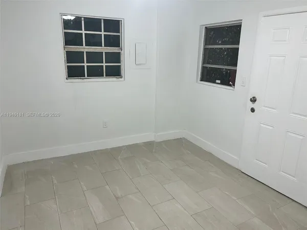 an empty room with windows and entrance