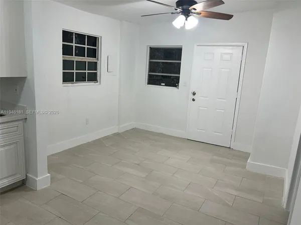 an empty room with windows and fan