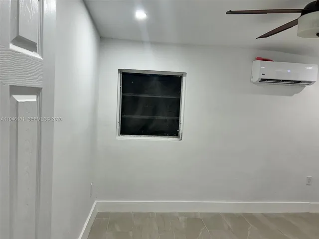 an empty room with windows and ceiling fan