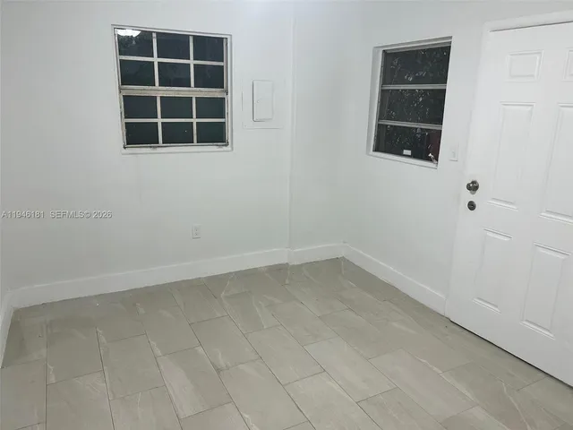 an empty room with windows and entrance