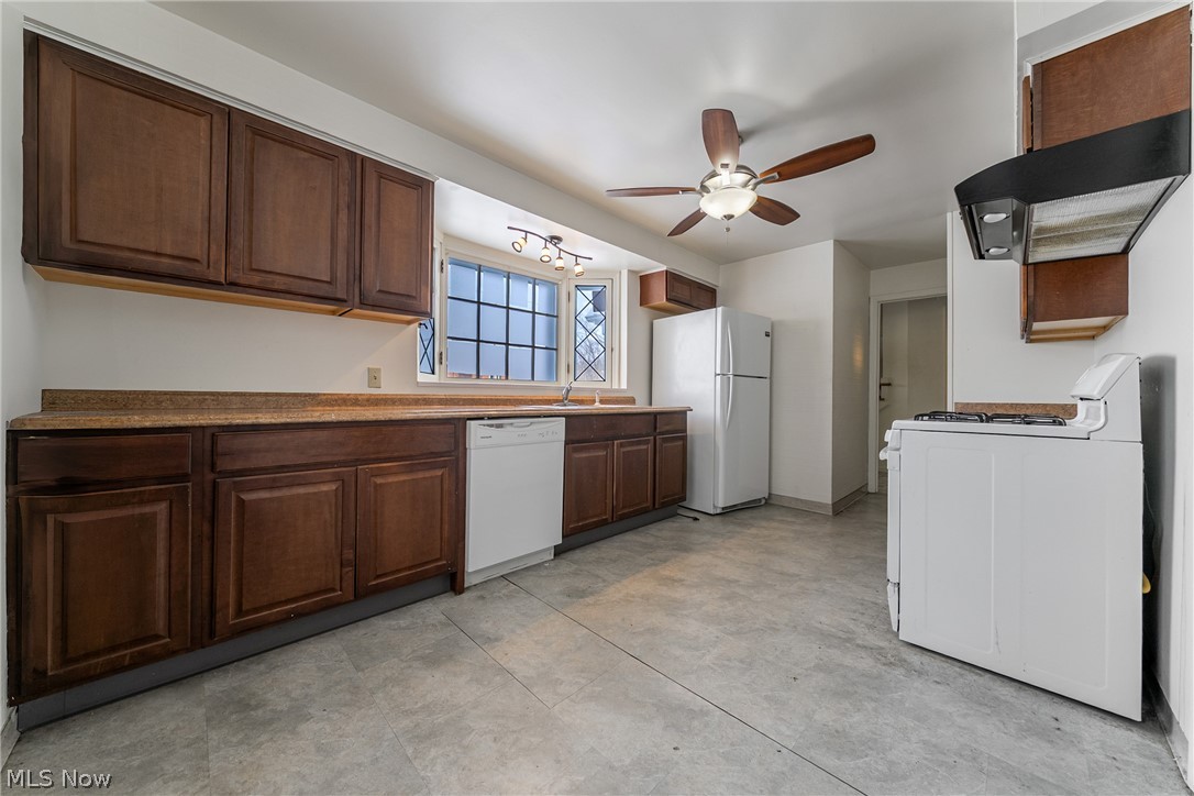 4602 College Road South Euclid, OH 44121 - Photo 8 of 26 Kitchen with white appliances, exhaust hood, ceiling fan, dark wood finish cabinetry, and dark countertops
