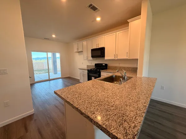 a kitchen with stainless steel appliances granite countertop a sink a microwave counter space and cabinets