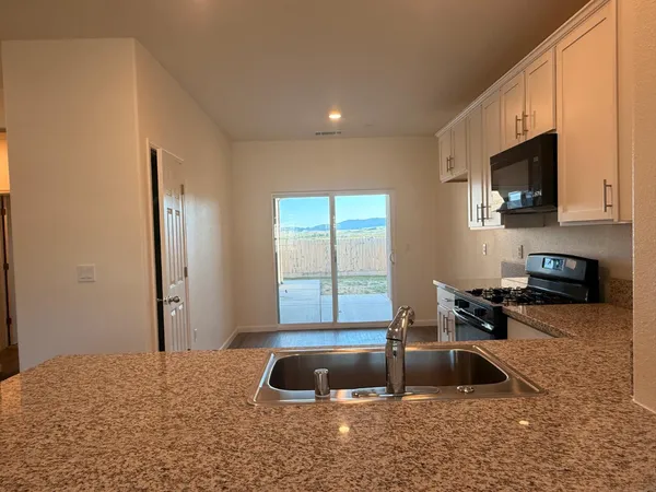 a kitchen with a sink and a stove top oven with wooden floor
