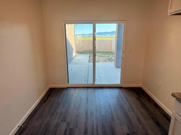an empty room with wooden floor and sliding door