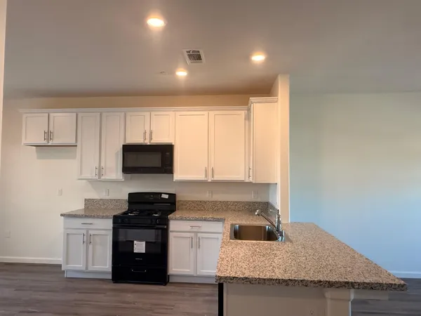 a kitchen with granite countertop a stove and a sink
