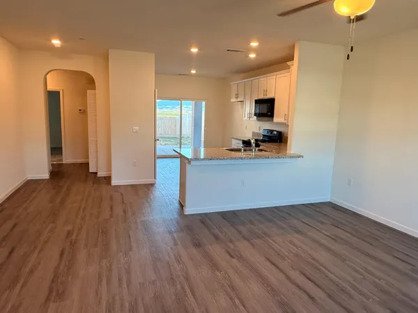 a view of a kitchen with wooden floor and a sink