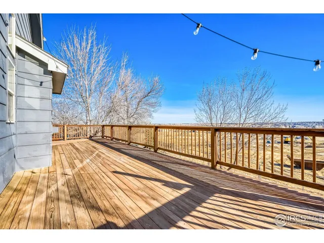 a view of a balcony with wooden floor and fence