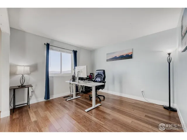 a view of a workspace with furniture and a window