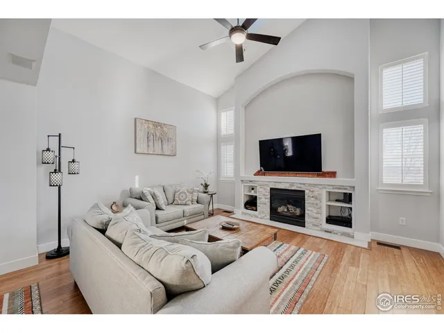 a living room with furniture a flat screen tv and a fireplace