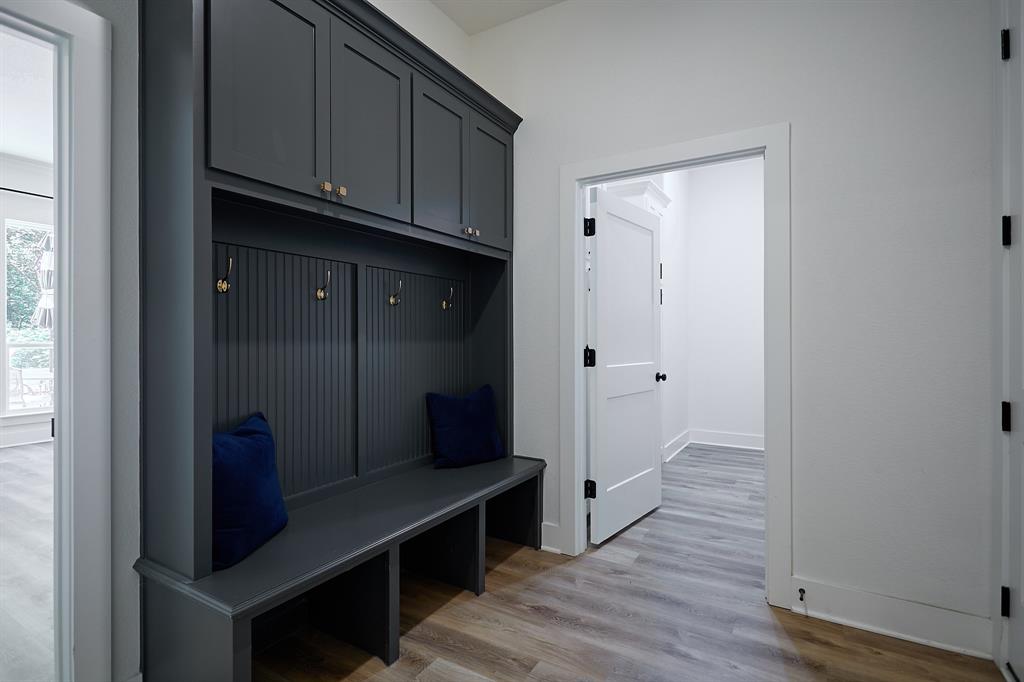358 Glade Valley Road Azle, TX 76020 - Photo 25 of 35 Built-in mudroom bench with beadboard backing, overhead cabinetry, and brass coat hooks